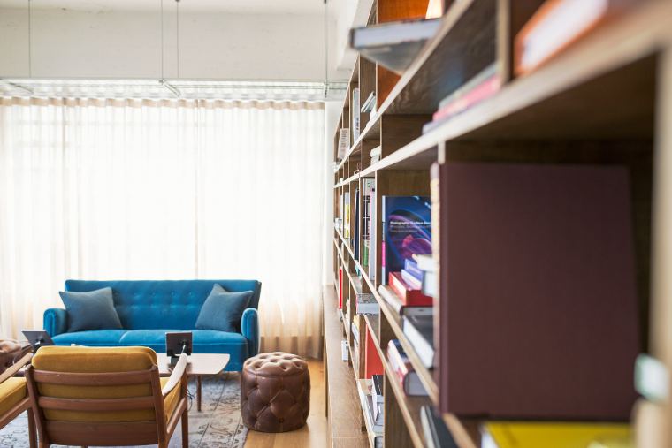 A quiet reading room with tall bookshelves and a blue sofa